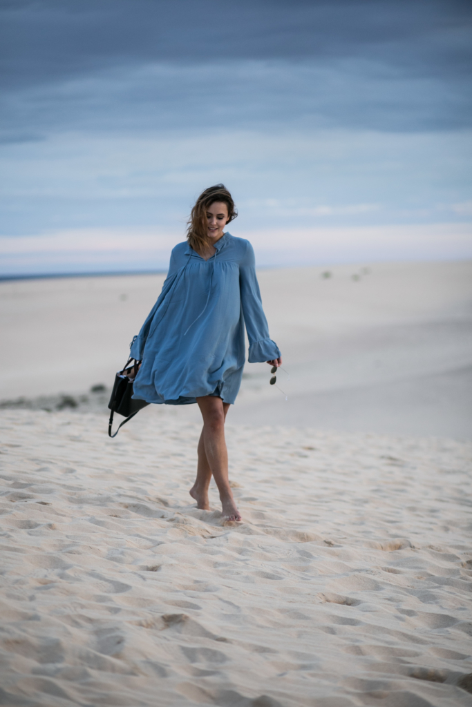 Strandbild - blaues Kleid, Tasche, Sonnenbrille