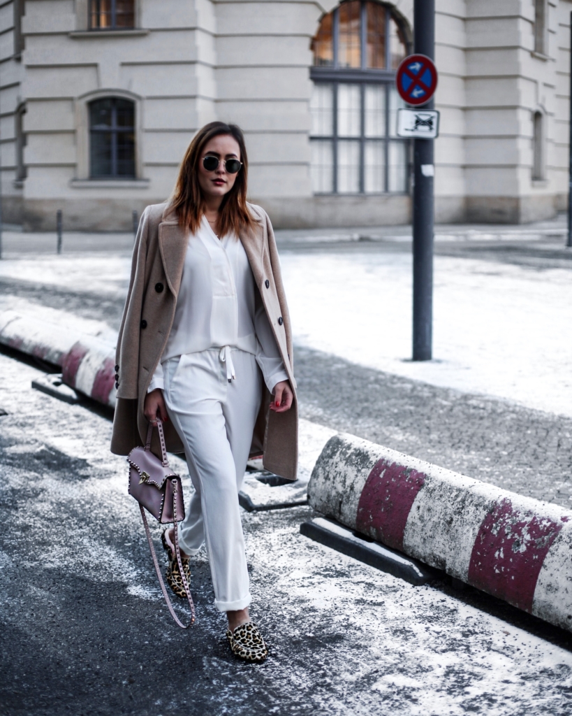 Weiße Hose + Bluse, beige Mantel, Tasche, Sonnenbrille 