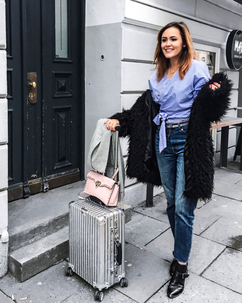 Streifenbluse, Koffer, Mantel, Schal, Jeans, Stiefeletten, Tasche