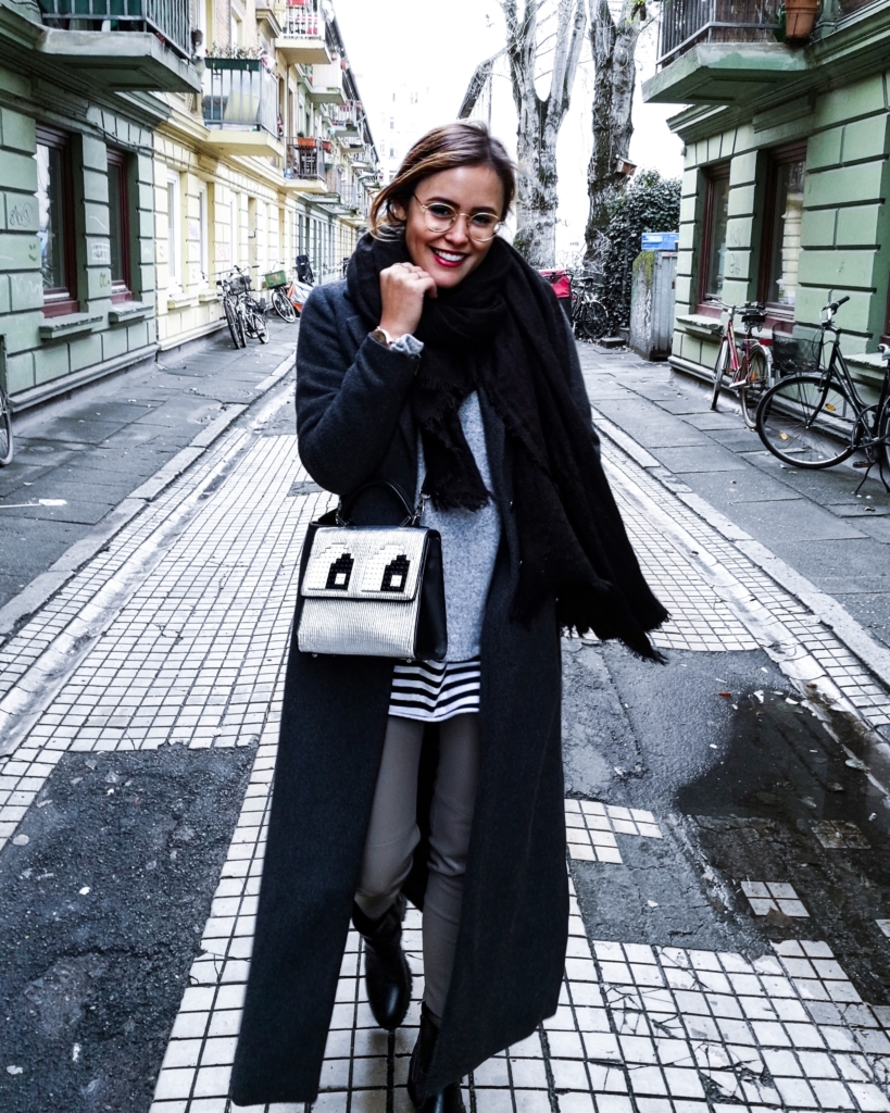 Streetstyle - schwarzer Schal + Mantel, Wollpullover, Streifenpullover, Jeans, Boots 