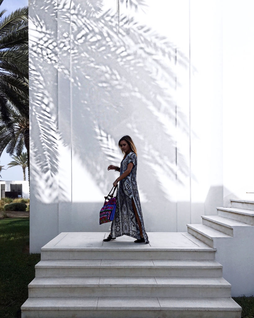 schwarz weißes Kleid, Treppe, Palmen, bunte Tasche 