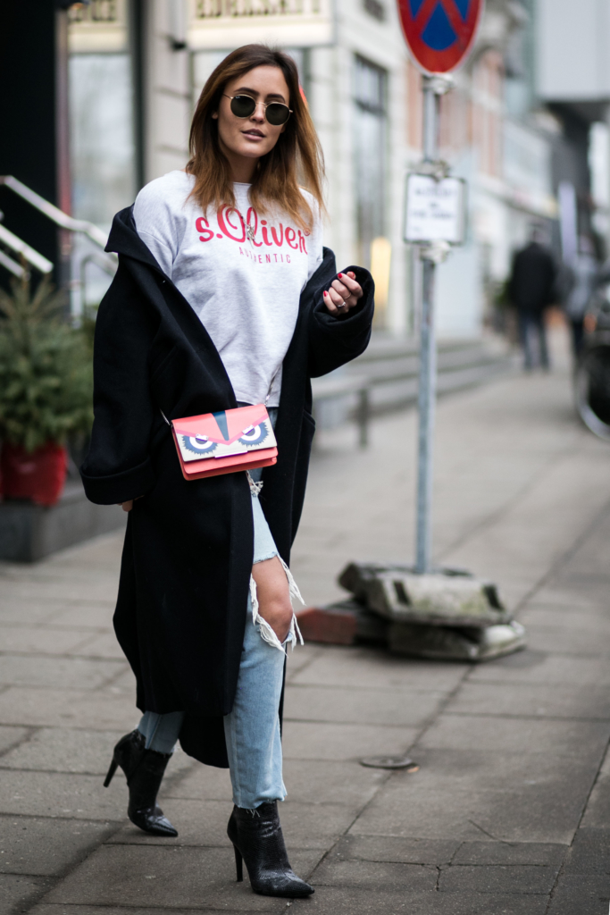  zerrissene Boyfriend Jeans in Kombination mit spitzen Python Stiefeletten und einem langen dunkelblauen Mantel, s.Oliver Shirt, Sonnenbrille, Tasche